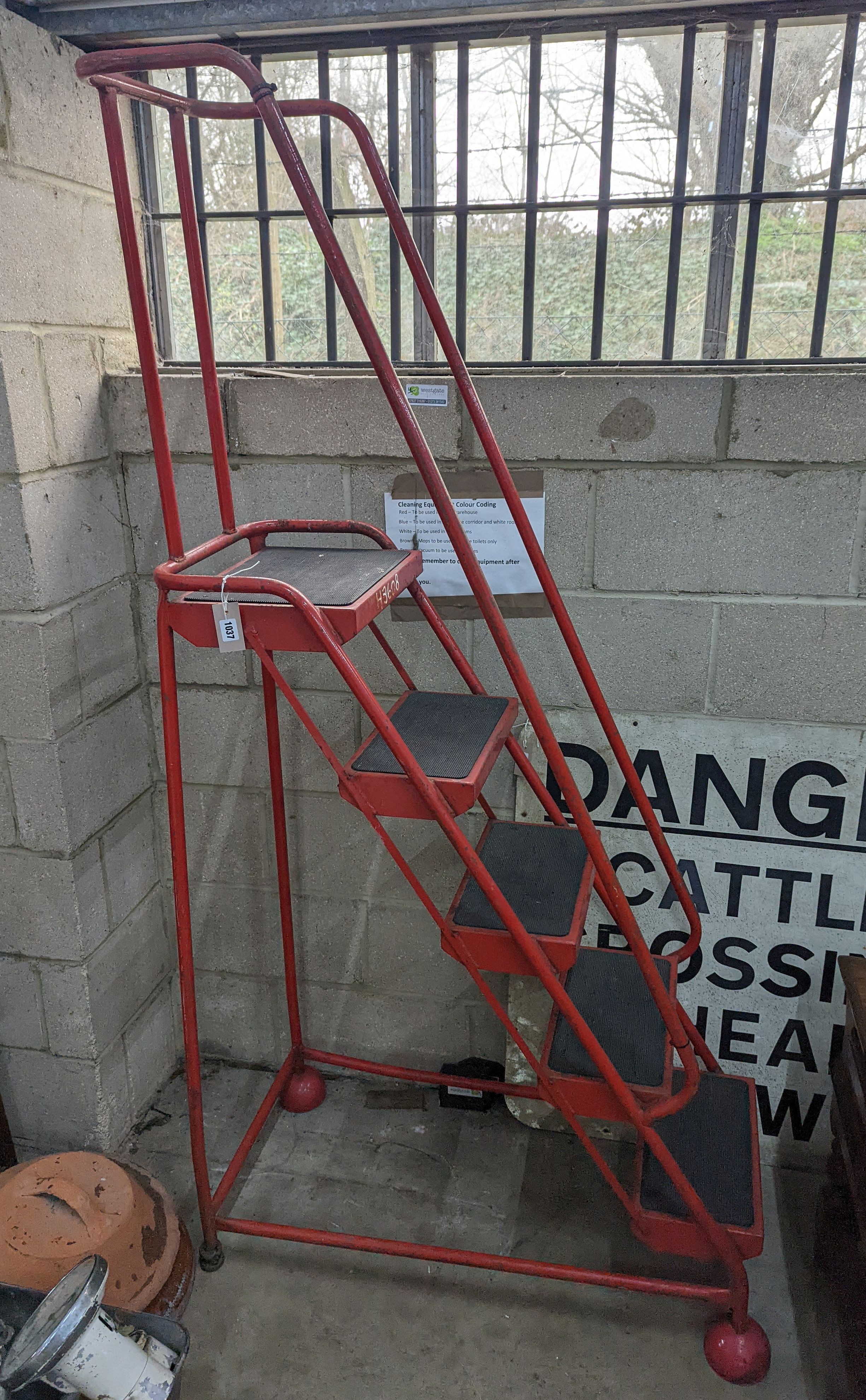 A set of red painted metal steps, height 188cm